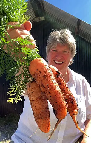 Liz from Byther Farm holding a bunch of carrots