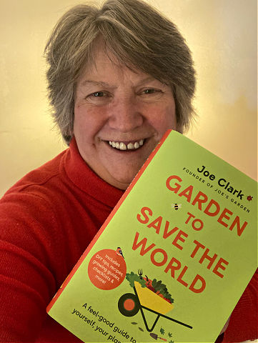 Liz Zorab holding Garden to Save the World book by Joe Clark of Joe's Garden